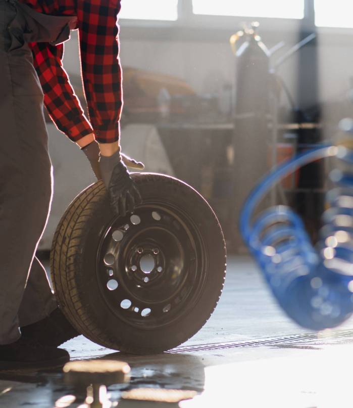 Man repairing a car wheel in a garage